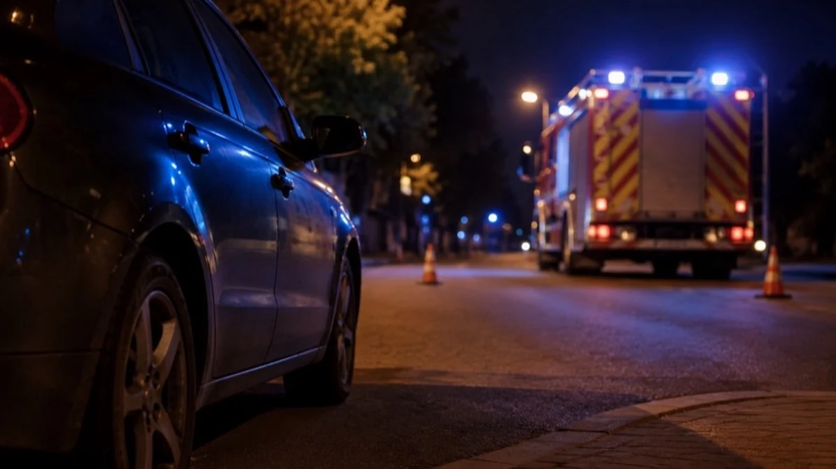 Geparktes Auto auf einem Parkplatz bei Nacht mit Feuerwehrfahrzeug im Hintergrund zum Thema Fahrzeugbrand