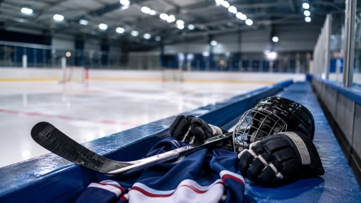 Eishockeyausrüstung mit Schläger und Trikot auf einer Spielerbank in einer Eishalle der Regionalliga