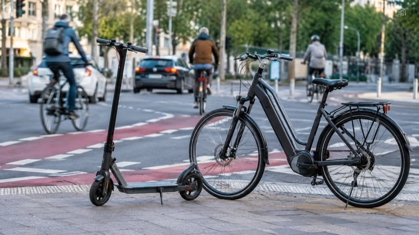 E-Scooter und Pedelec an einer Kreuzung im Stadtverkehr von Sachsen-Anhalt mit Radweg und vorbeifahrenden Fahrzeugen