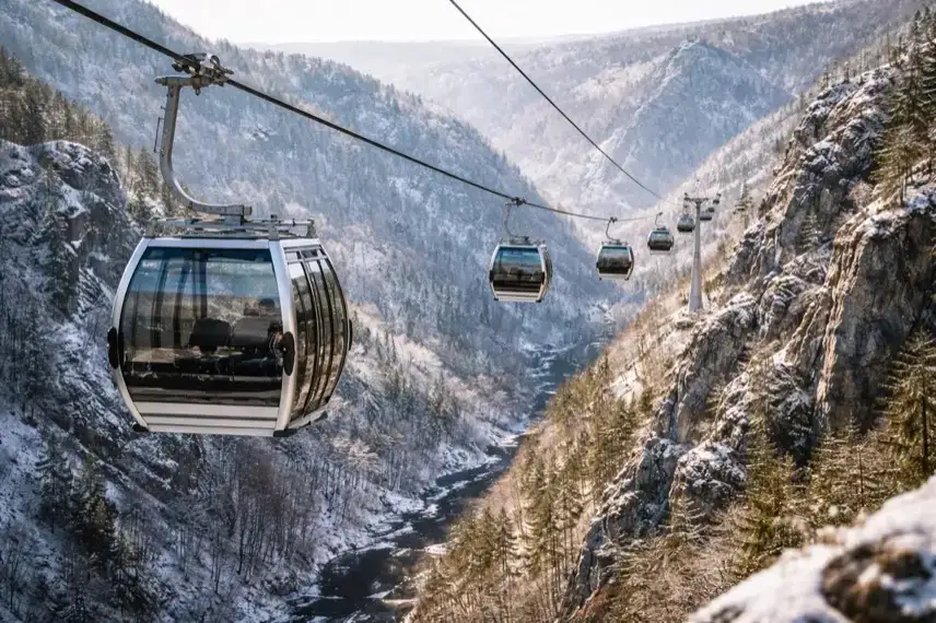 Mehrere Kabinen der Seilbahn in Thale schweben über dem Bodetal mit Felsen und bewaldeten Hängen im Harz.