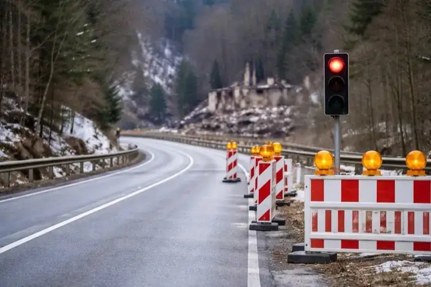 Halbseitig gesperrte Bundesstraße 498 im Okertal mit Ampelanlage und Trümmern einer Brandruine am Straßenrand